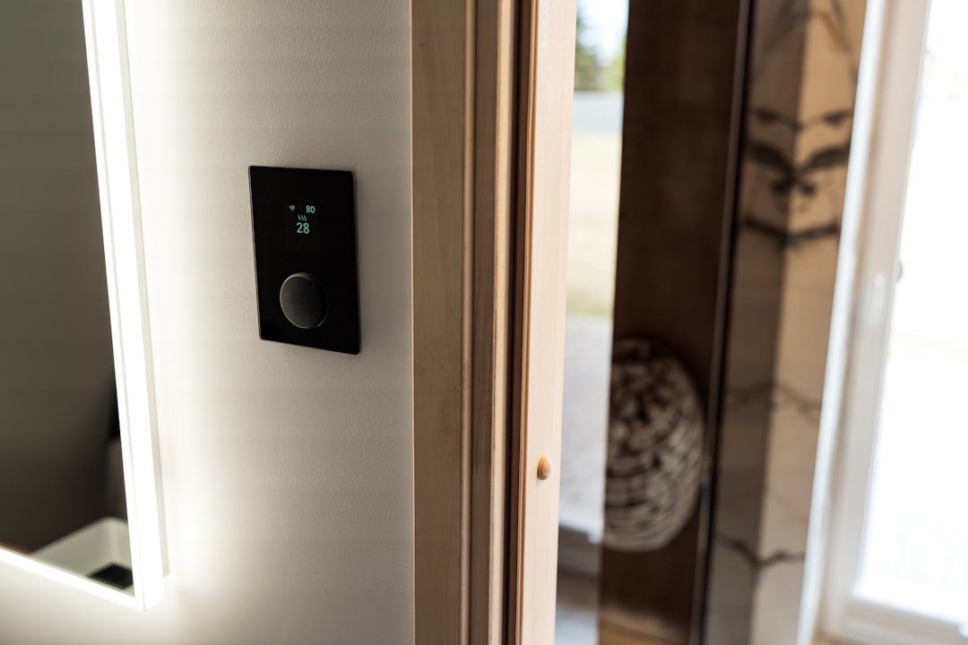 close up of a hand adjusting a thermostat in a modern home