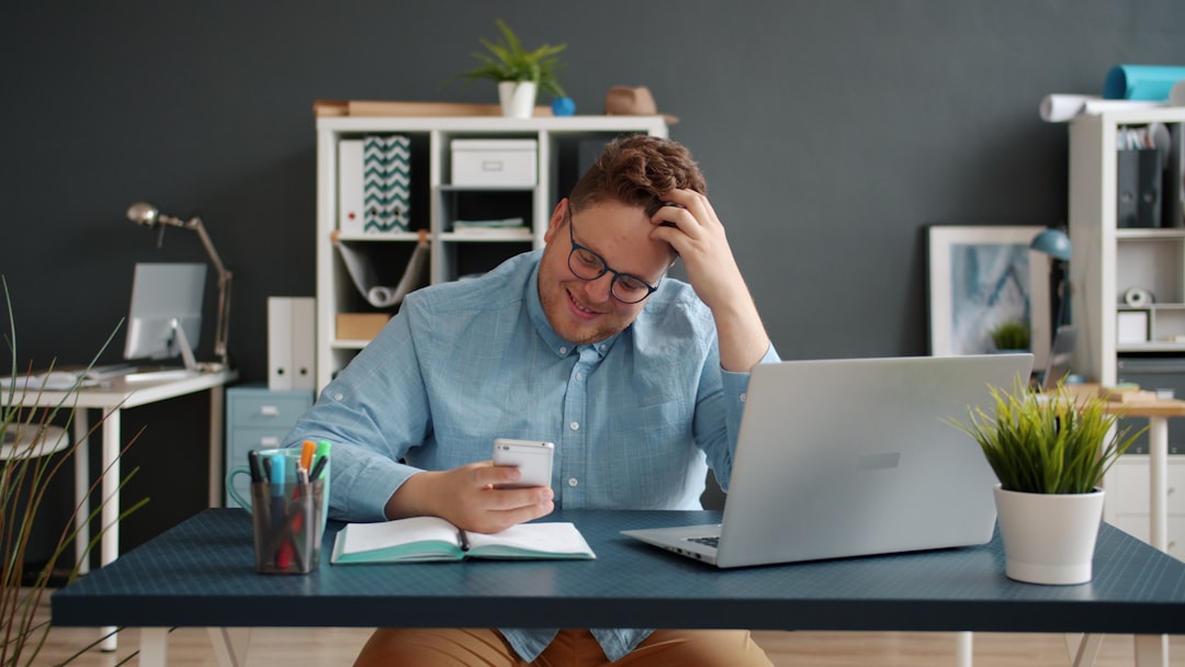 stressed person at a laptop with a phone and calendar open